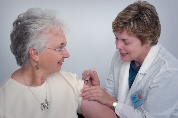 Healthcare professional giving a flu vaccine to an elderly patient